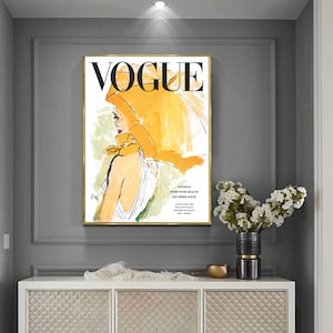 May include: A vintage Vogue magazine cover featuring a woman wearing a yellow headscarf and a white dress. The cover text reads "VOGUE" in black letters.