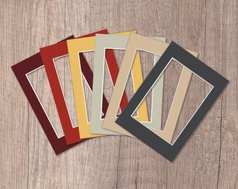 May include: A set of seven different colored mat boards, each with a white core and a rectangular opening. The mat boards are arranged in a fan shape, with the darkest color at the bottom and the lightest color at the top.