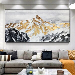 May include: Abstract painting of a mountain range with white, gray, and gold paint. The mountain peaks are covered in snow and the valleys are filled with a golden hue.