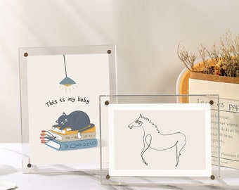 May include: Two clear acrylic picture frames with black cat and horse illustrations. The cat illustration shows a black cat sleeping on a stack of books with the text "This is my baby". The horse illustration is a simple line drawing of a horse.