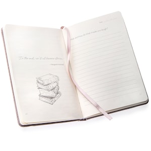 May include: An open journal with a pink ribbon bookmark. The left page features a quote by Margaret Atwood: "In the end, we'll all become stories."  The right page has the prompt: "What did they do that made you laugh?"