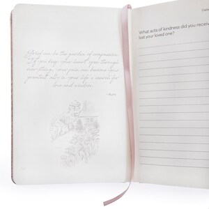 May include: An open journal with a pink ribbon bookmark. The left page features a quote by Rumi: "Grief can be the garden of compassion. If you keep your heart open through everything, your pain can become your greatest ally in your life's search for love and wisdom." The right page has the text "What acts of kindness did you receive when you lost your loved one?" and lined paper for writing.