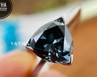 Pode incluir: Um anel de prata com uma gema triangular azul escura.