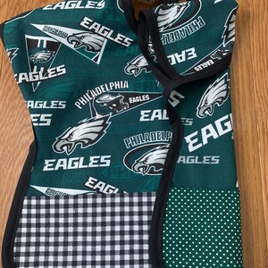 May include: Green and black fabric bib with a checkered pattern and a green fabric with white polka dots. The fabric features the Philadelphia Eagles logo and the words "Philadelphia Eagles".