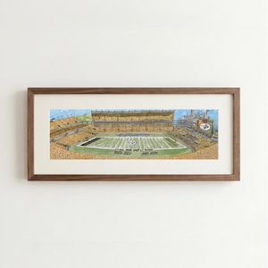 May include: A panoramic watercolor illustration of a football stadium filled with spectators wearing yellow and black, framed in a dark wood frame. The field is green with white yard lines and a central logo, under a light blue sky.