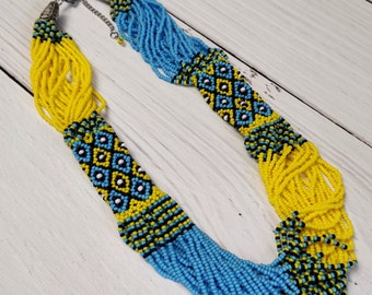 Collar azul amarillo. Collar de cuentas de semillas hecho a mano. Collar ucraniano. Un collar con un adorno geométrico. Collar con cuerdas. Gerdán.