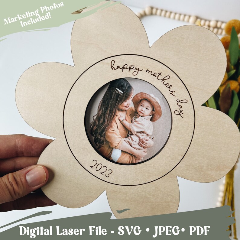 May include: A wooden flower-shaped picture frame with a circular cutout for a photo. The frame is engraved with the text "happy mothers day" and the year "2023".