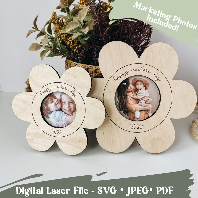 May include: Two wooden flower-shaped picture frames with a cutout for a photo. The frames are engraved with the text "Happy Mother's Day" and the year "2023".