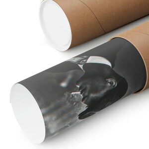 May include: A black and white photograph of a person smoking a cigarette. The photograph is rolled up and inside a brown cardboard tube.