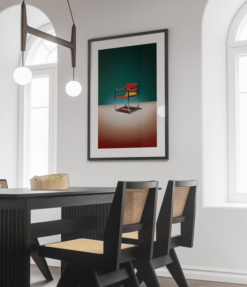 May include: A black framed picture with a colorful chair on a teal background. The chair is red, yellow, and black. The picture is hanging on a white wall above a black dining table with two black chairs.