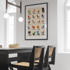 K&ouml;nnte beinhalten: Ein schwarzer gerahmter Poster mit wei&szlig;em Hintergrund, der eine Sammlung bunter St&uuml;hle zeigt. Der Poster h&auml;ngt an einer wei&szlig;en Wand &uuml;ber einem schwarzen Esstisch mit zwei schwarzen St&uuml;hlen mit geflochtenen Korbsitzen.