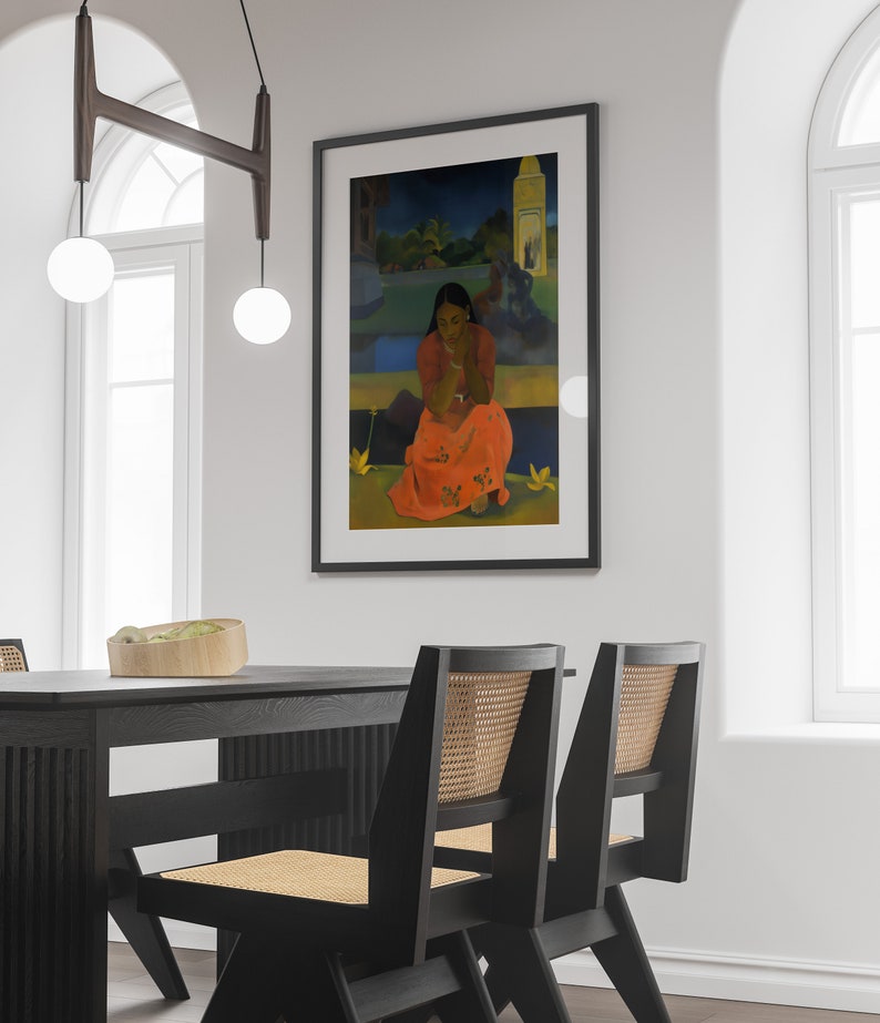 Peut inclure: Une peinture encadr&eacute;e d'une femme en robe rouge et blanche assise dans un jardin. La peinture est dans un cadre noir et est accroch&eacute;e &agrave; un mur blanc.