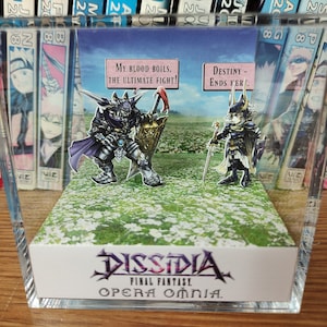 May include: A 3D pop-up diorama of the video game Dissidia Final Fantasy Opera Omnia. The diorama features two characters from the game, one with a sword and the other with a shield. The diorama is set against a backdrop of a green field with white flowers.