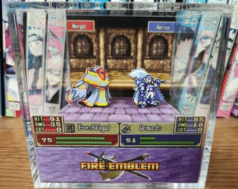 May include: A clear acrylic display case with a purple background featuring a pixelated image of two characters from the Fire Emblem video game series. The characters are Ereshkigal and Armads. The text "FIRE EMBLEM" is printed in white on the bottom of the case.