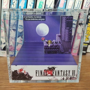 May include: A clear acrylic display case with a purple base and a 3D diorama of a scene from Final Fantasy VI. The diorama features a character standing on a rooftop with a castle in the background. The moon is visible in the sky. The text "FINAL FANTASY VI" is printed on the base of the case.