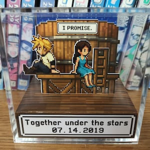 May include: A pixel art diorama in a clear acrylic case. It features two figures sitting on a wooden structure with the text "I PROMISE." The base reads "Together under the stars 07.14.2019."