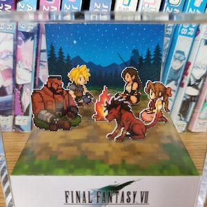 May include: A pixel art diorama of Final Fantasy VII characters around a campfire under a starry night. The scene is set within a clear acrylic box, with the game's logo displayed at the base.