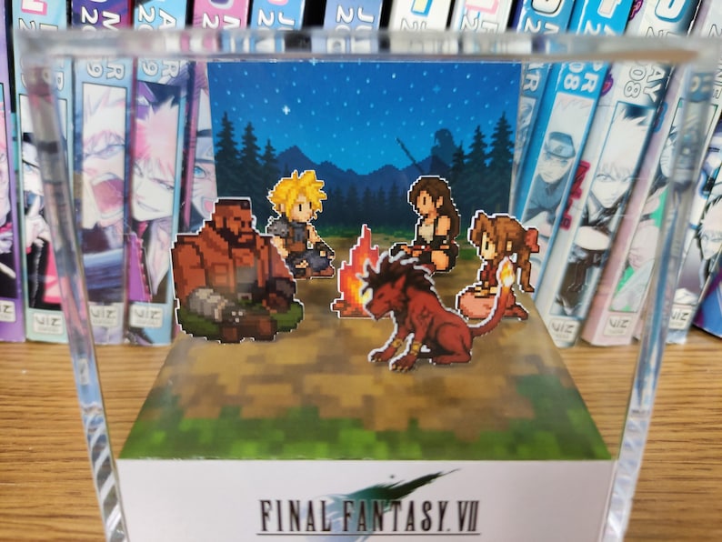 May include: A pixel art diorama of Final Fantasy VII characters around a campfire under a starry sky, within a clear acrylic box. The game's logo is displayed at the base of the diorama.