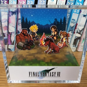 May include: A Final Fantasy VII pixel art diorama, depicting characters around a campfire beneath a starry night. The scene is set within a clear acrylic block, with the game's logo displayed at the bottom.