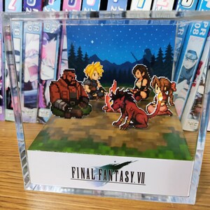 May include: A Final Fantasy VII pixel art diorama. The scene shows a campfire with several characters, set against a starry night backdrop. The diorama is encased in a clear acrylic box, with the game's logo at the base.