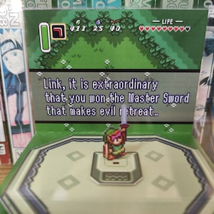 May include: A video game screen showing a green background with a character in the center. The text on the screen reads "Link, it is extraordinary that you won the Master Sword that makes evil retreat..."