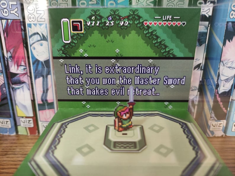 May include: A video game screen showing a green background with a character in the center. The text on the screen reads "Link, it is extraordinary that you won the Master Sword that makes evil retreat..."