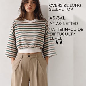 May include: An oversize long sleeve top with horizontal green and brown stripes, a white crew neckline, and a white cinched waist hem. Text reads: OVERSIZE LONG SLEEVE TOP, XS-3XL, A4-A0-LETTER, PATTERN+GUIDE, DIFFICULTY LEVEL, and two black stars.