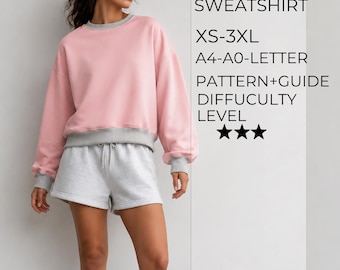 Puede incluir: Una sudadera rosa con cuello redondo, puños y dobladillo grises, combinada con pantalones cortos grises. El texto dice: PINKY SWEATSHIRT, XS-3XL, A4-A0-LETTER, PATTERN+GUIDE, DIFFUCULTY LEVEL, y tres estrellas negras que indican el nivel.