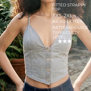 May include: A grey fitted strappy top with a V-neckline and four front buttons. Text on the image reads: FITTED STRAPPY TOP, XXS-2XL, A4-A0-LETTER, PATTERN+GUIDE, DIFFICULTY LEVEL, and three stars. The top has thin shoulder straps and a pointed hem.