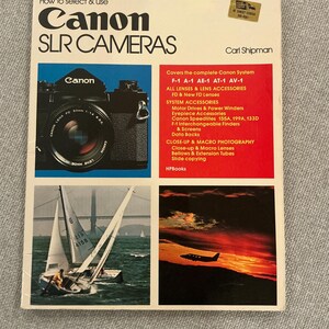 Könnte beinhalten: Ein Buchcover mit dem Titel "How to select & use Canon SLR Cameras" mit einem Canon-Fotoapparat auf rotem Hintergrund. Das Buchcover enthält außerdem zwei Fotos, eines von einem Segelboot und eines von einem Flugzeug, das über einem Sonnenuntergang fliegt.