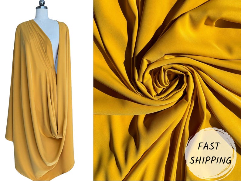 May include: A mustard yellow fabric draped over a mannequin. The fabric is soft and flowing, with a slight sheen. The fabric is shown in a close-up, with the folds and wrinkles visible. The text "FAST SHIPPING" is visible in the lower right corner of the image.