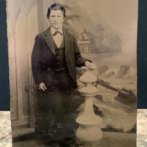 Antique tintype photograph of a well-dressed young boy in a studio