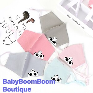 May include: Five fabric face masks with panda bear designs. The masks are in various colors, including pink, gray, and blue. The text "BabyBoomBoom Boutique" is at the bottom of the image.