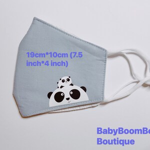 May include: A light blue face mask with white elastic straps. The mask features a black and white panda bear design with the text "19cm*10cm (7.5 inch*4 inch)" and "BabyBoomBoom Boutique".