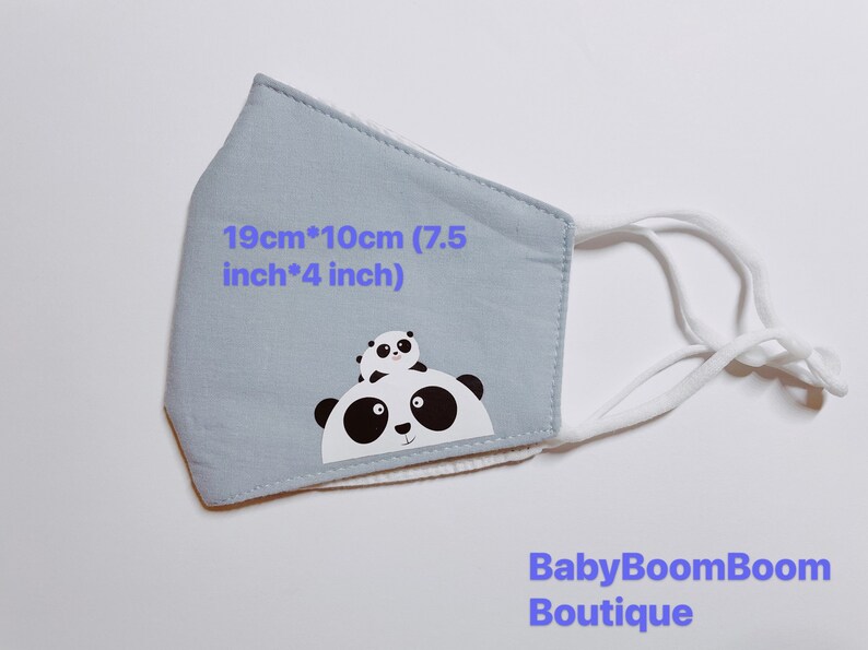 May include: A light blue face mask with white elastic straps. The mask features a black and white panda bear design with the text "19cm*10cm (7.5 inch*4 inch)" and "BabyBoomBoom Boutique".