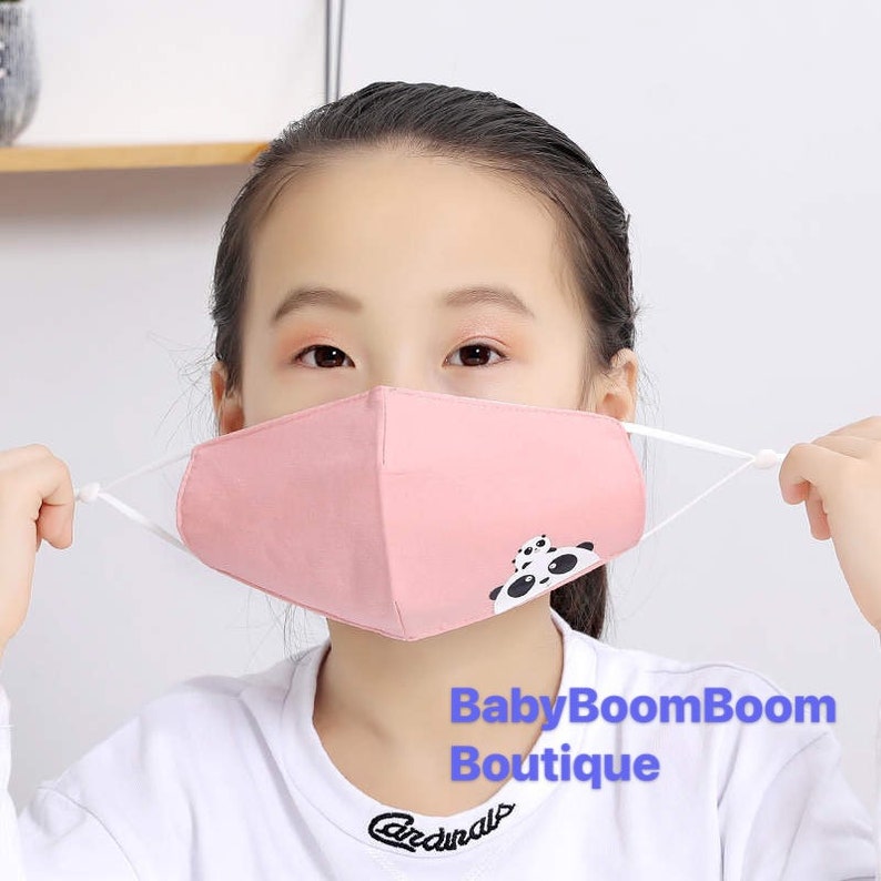 May include: A pink face mask with a panda bear design. The mask has elastic ear loops and is made of soft, breathable fabric.  The text "BabyBoomBoom Boutique" is visible in the image.