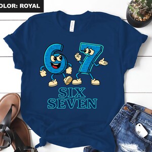 May include: Royal blue t-shirt featuring the numbers six and seven as cartoon characters with arms, legs, and facial expressions. The words "SIX SEVEN" are printed in a light blue, outlined font below the characters. The shirt is displayed on a white surface.
