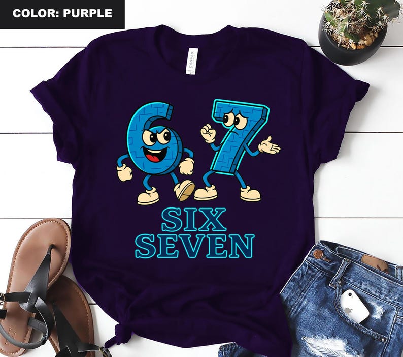 May include: Purple t-shirt featuring the numbers six and seven as cartoon characters with arms, legs, and facial expressions. The words "SIX SEVEN" are printed below the numbers in a blue, outlined font.