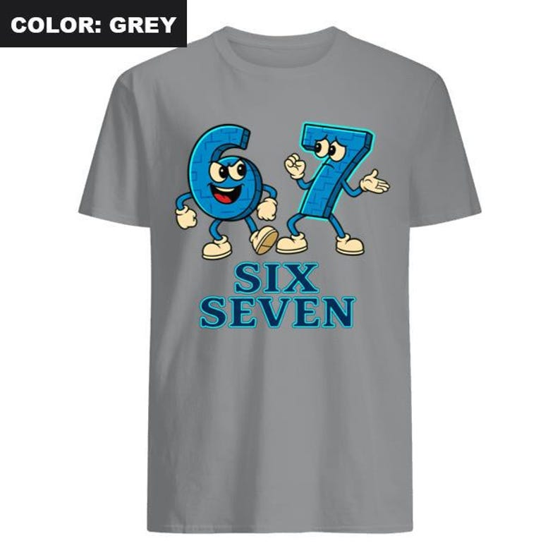 May include: A grey t-shirt featuring a cartoon graphic of the numbers six and seven with arms, legs, and facial expressions. The words "SIX SEVEN" are printed below the numbers in blue. The shirt is a solid grey color.