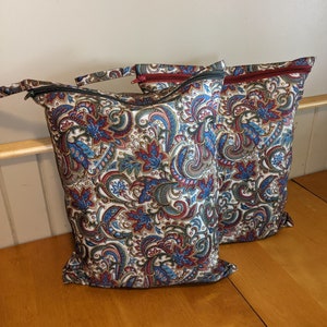 May include: Two paisley patterned zippered bags with red zipper pulls. The bags are made of a soft, durable fabric and have a large capacity.