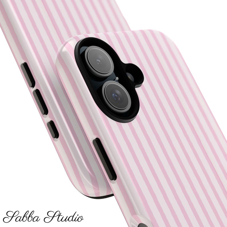 Op de afbeelding: Twee roze en wit gestreepte telefoonhoesjes. De hoesjes hebben een glanzende afwerking en een zwart cameramodule. De tekst "Sabba Studio" staat onderaan de afbeelding.