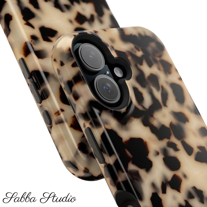 May include: Close-up of two phone cases with a tortoiseshell pattern in shades of beige, brown, and black. The cases have a glossy finish and feature camera cutouts and side buttons.