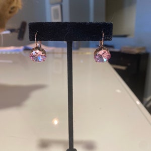 Aretes de cristal Swarovski de 12 mm de talla cojín en color rosa/rosa con engaste de puntas chapado en oro rosa y ganchos tipo palanca.