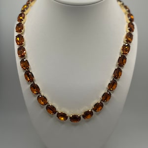 This is a beauty! Swarovski crystal Anna Wintour tennis necklace in  topaz 14x10 oval gold plated setting.