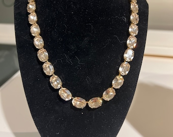 Puede incluir: Un collar de cadena dorada con grandes cristales ovalados transparentes.