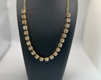 Swarovski-kristall Anna Wintour tennishalsband i guldpläterad infattning i ljus siden.