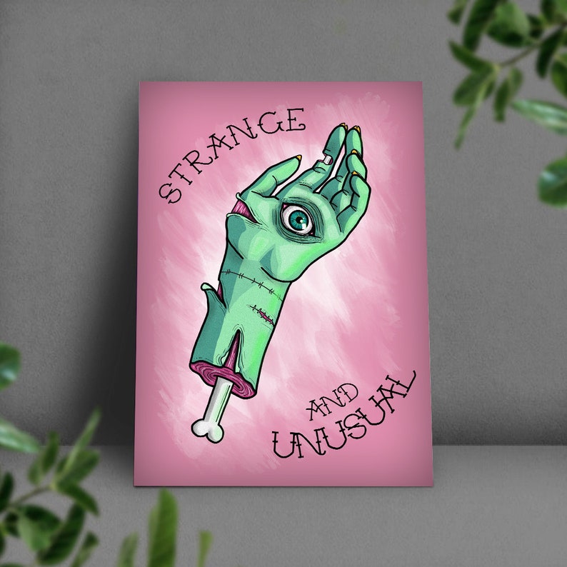 May include: A pink background with the text "STRANGE AND UNUSUAL" in black. A green zombie hand with a single eye is reaching up.