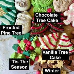 May include: A collection of festive, colorful, and decorative soaps in various shapes. The soaps include frosted pine trees, chocolate tree cakes, and vanilla tree cakes. The text on the image reads "'Tis The Season" and "Winter Spice".