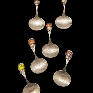 Puede incluir: Conjunto de seis cucharas de plata con cuentas de vidrio de colores en los mangos. Las cucharas tienen un diseño decorativo en el cuenco y son perfectas para servir té o postre.