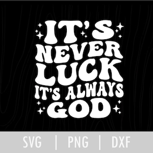 Op de afbeelding: Witte tekst op een zwarte achtergrond leest "IT'S NEVER LUCK IT'S ALWAYS GOD" in een retro lettertype. De tekst is omgeven door kleine sterretjes. De onderkant van de afbeelding heeft de tekst "SVG | PNG | DXF".